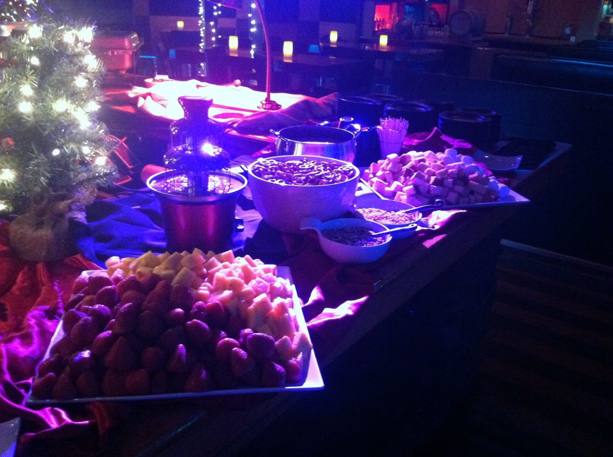 Chocolate fountain dessert table with strawberries, cut fruit and marshmallows